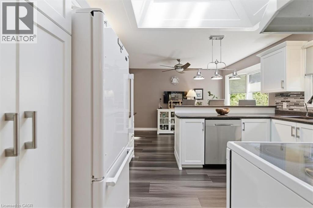 Kitchen featuring white cabinetry, stainless steel dishwasher, dark countertops, and a tiled backsplash - 26 Sideroad 18, Fergus, ON - Indoor Photo Showing Kitchen