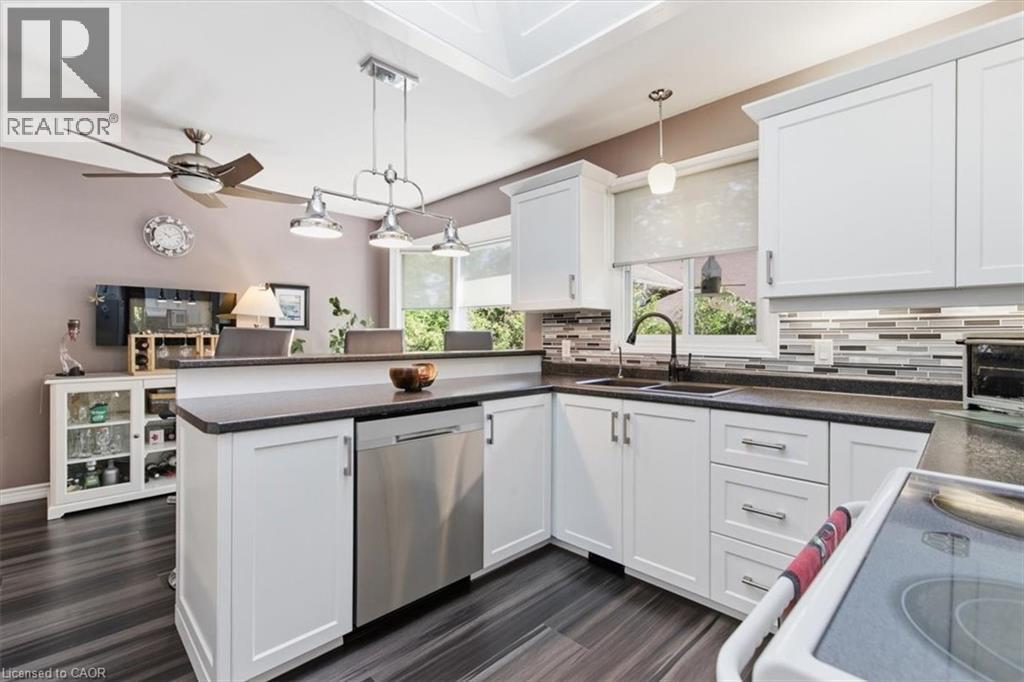 White shaker cabinetry with dark countertops, stainless steel dishwasher, and mosaic tile backsplash - 26 Sideroad 18, Fergus, ON - Indoor Photo Showing Kitchen With Double Sink