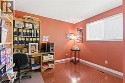 Room featuring wood-finish flooring, a single window with blinds, and contrasting wall color -