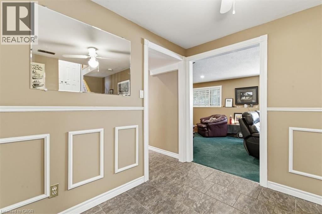 Hallway featuring wainscoting with decorative trim, tile flooring, and a large wall mirror - 26 Sideroad 18, Fergus, ON -