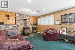 Stone accent wall with a wood-burning stove and a slate hearth -