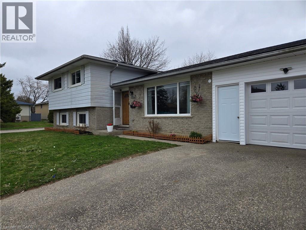 Split-level residence featuring a single-car garage with a panel door and upper window inserts - 261 Overlea Drive, Kitchener, ON