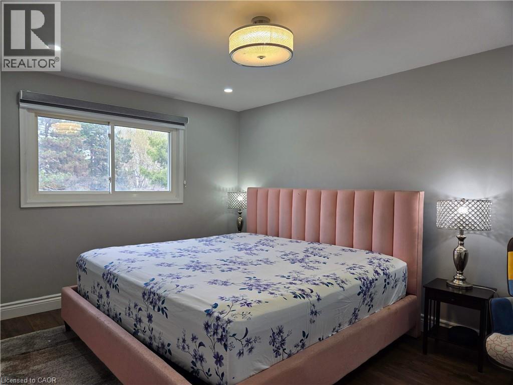 Bedroom featuring recessed lighting, a central drum ceiling fixture, and wood-finish flooring - 261 Overlea Drive, Kitchener, ON