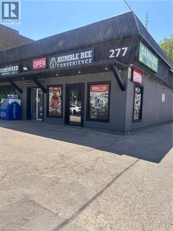 Commercial storefront property featuring a dark grey facade with black trim - 277 Lancaster Street W, Kitchener, ON
