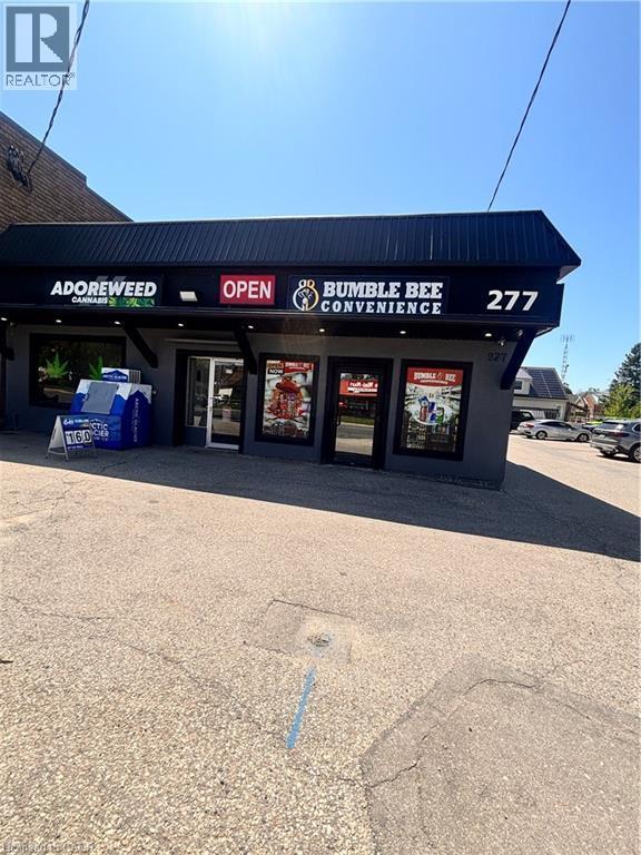 Commercial storefront featuring a dark gray facade and a black corrugated metal awning - 277 Lancaster Street W, Kitchener, ON