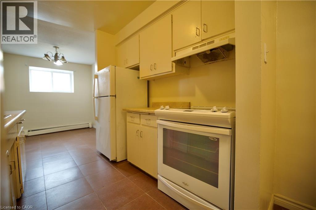 Kitchen featuring white cabinetry, a freestanding electric range, and a refrigerator - 223 Heiman Street Unit# Unit 2, Kitchener, ON - Indoor Photo Showing Kitchen