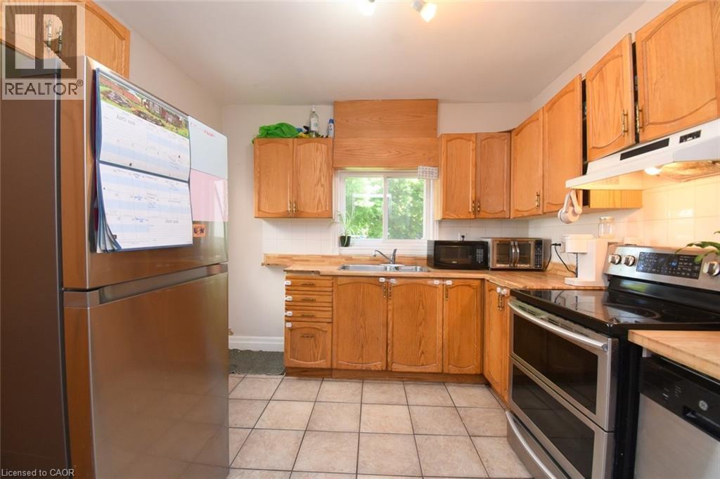 Kitchen featuring light wood cabinetry, a stainless steel electric range, and tile flooring - 12 Wood Street W, Hamilton, ON - Indoor Photo Showing Kitchen With Double Sink