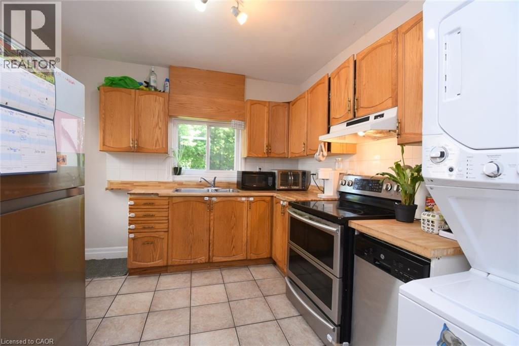 Kitchen featuring wood-finish cabinetry, stainless steel appliances, and a tiled floor - 12 Wood Street W, Hamilton, ON - Indoor
