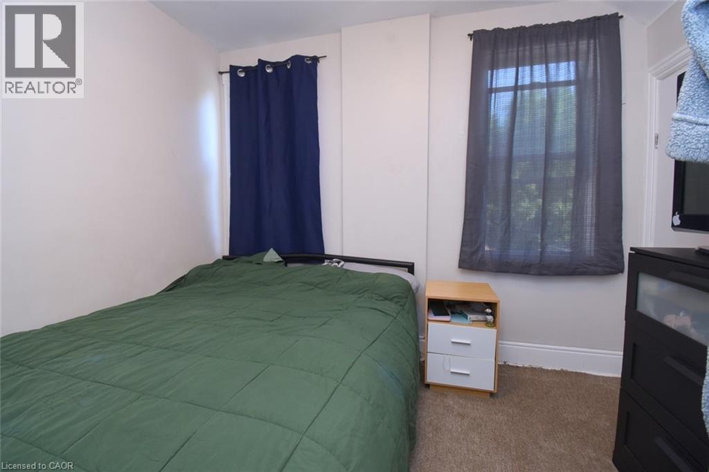 Carpeted room featuring white walls and multiple windows - 12 Wood Street W, Hamilton, ON - Indoor Photo Showing Bedroom