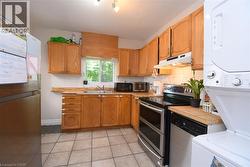 Kitchen featuring wood-finish cabinetry, stainless steel appliances, and a tiled floor -