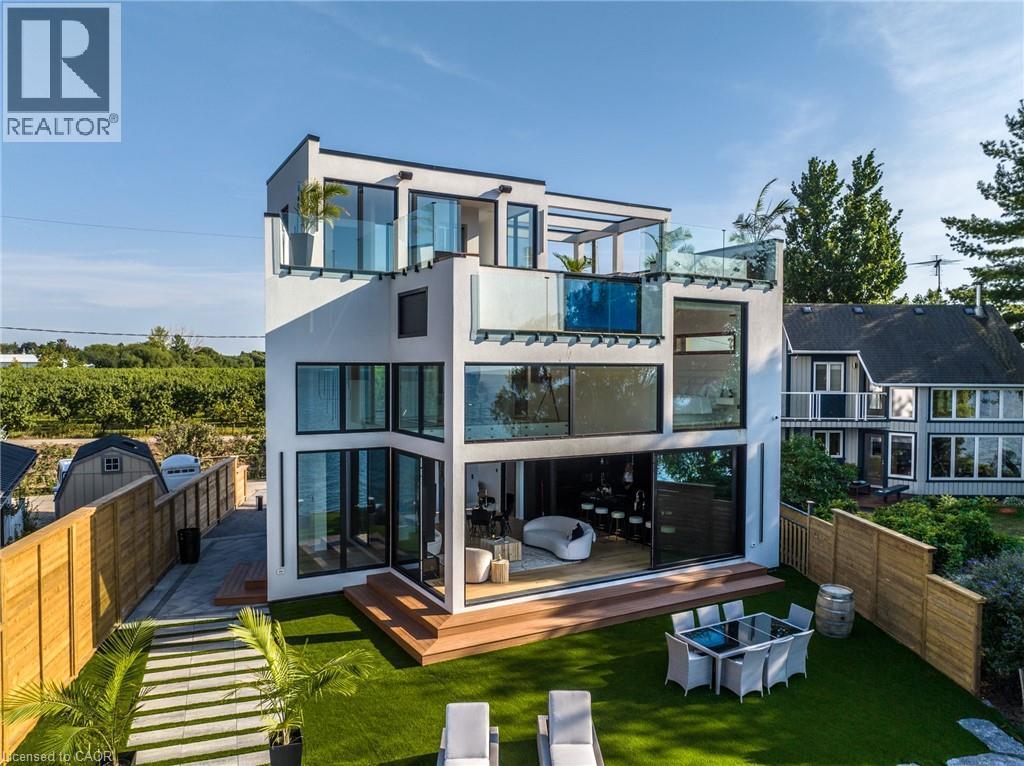 Contemporary multi-story residence featuring expansive glass panels, multiple outdoor terraces with glass railings, and a ground-level deck with artificial turf - 6 Firelane 11A Street, Niagara-On-The-Lake, ON - Outdoor