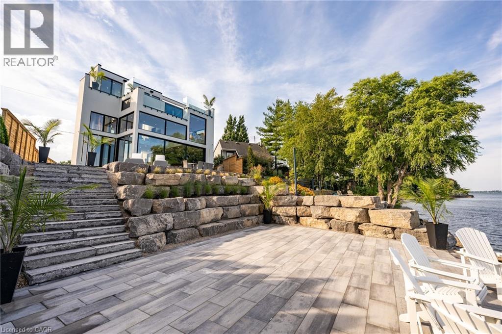 Contemporary multi-level residence with extensive glass facade and multiple balconies - 6 Firelane 11A Street, Niagara-On-The-Lake, ON - Outdoor With Body Of Water With Deck Patio Veranda