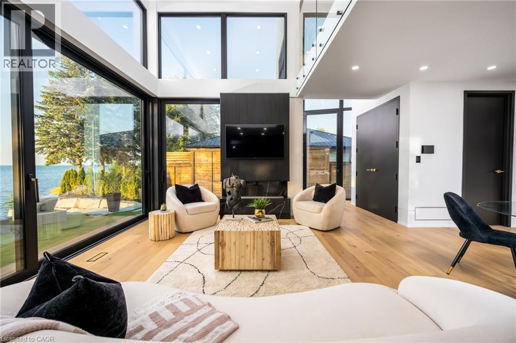 Expansive living area featuring soaring ceilings and oversized windows offering water scenery - 6 Firelane 11A Street, Niagara-On-The-Lake, ON - Indoor Photo Showing Living Room