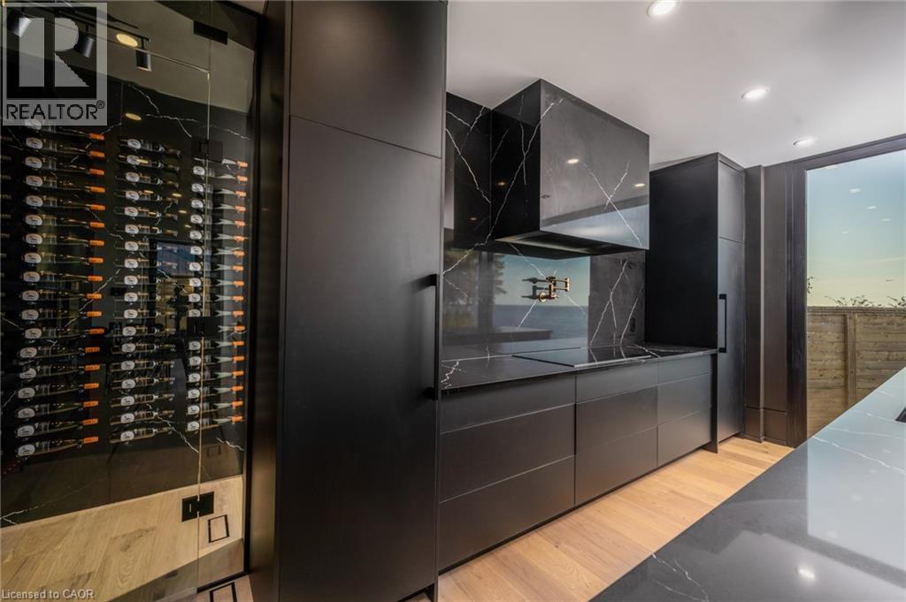 Sleek modern kitchen featuring black slab cabinetry and black countertops with white veining - 6 Firelane 11A Street, Niagara-On-The-Lake, ON - Indoor