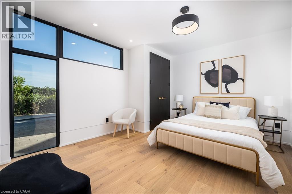 Spacious bedroom featuring light wood-finish flooring, recessed lighting, and a modern ceiling fixture - 6 Firelane 11A Street, Niagara-On-The-Lake, ON - Indoor Photo Showing Bedroom