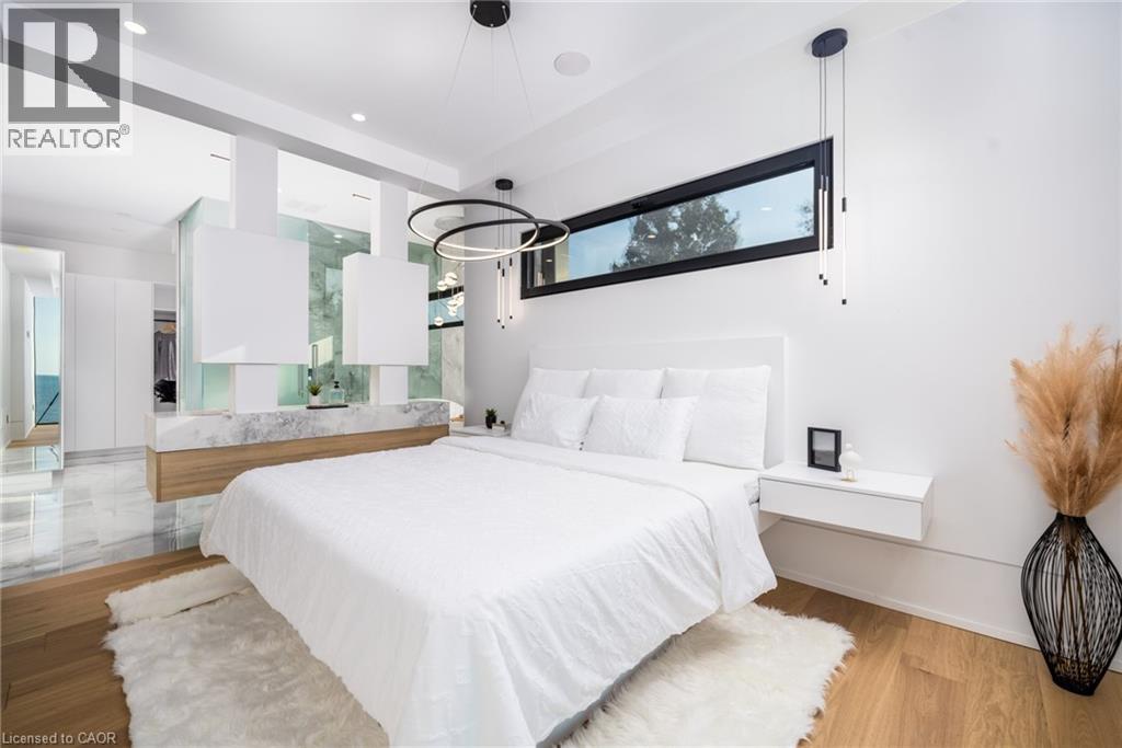 Contemporary bedroom featuring a wood-finish floor and a built-in floating nightstand - 6 Firelane 11A Street, Niagara-On-The-Lake, ON - Indoor Photo Showing Bedroom