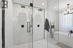 Modern bathroom featuring a spacious glass-enclosed shower with dual rain showerheads and matte black fixtures -