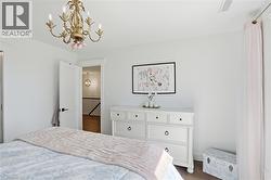 White interior space featuring a multi-bulb chandelier with ornate gold-tone detailing -