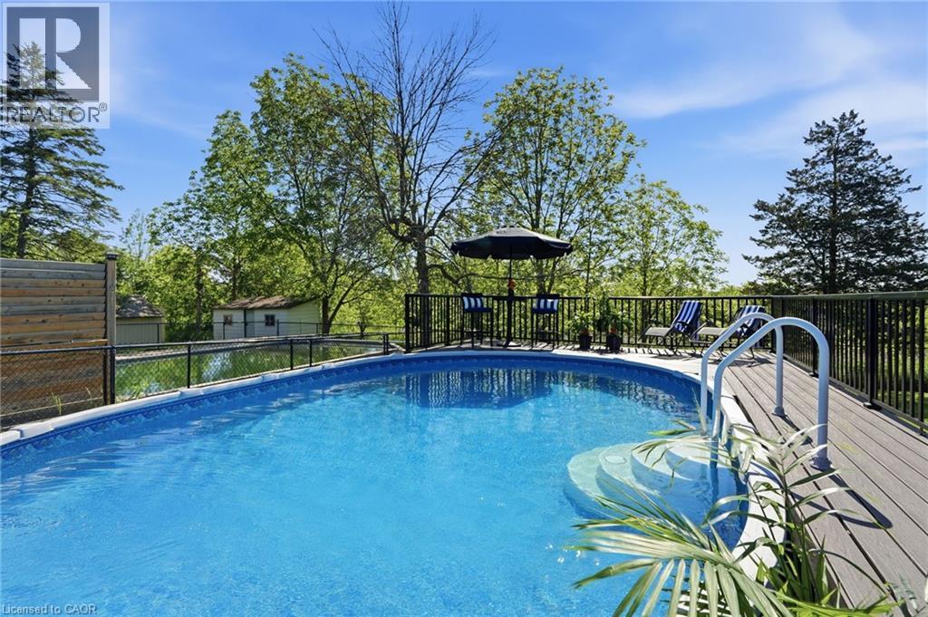 Above-ground pool featuring integrated steps and a surrounding composite deck - 71 Miles Road, Hamilton, ON