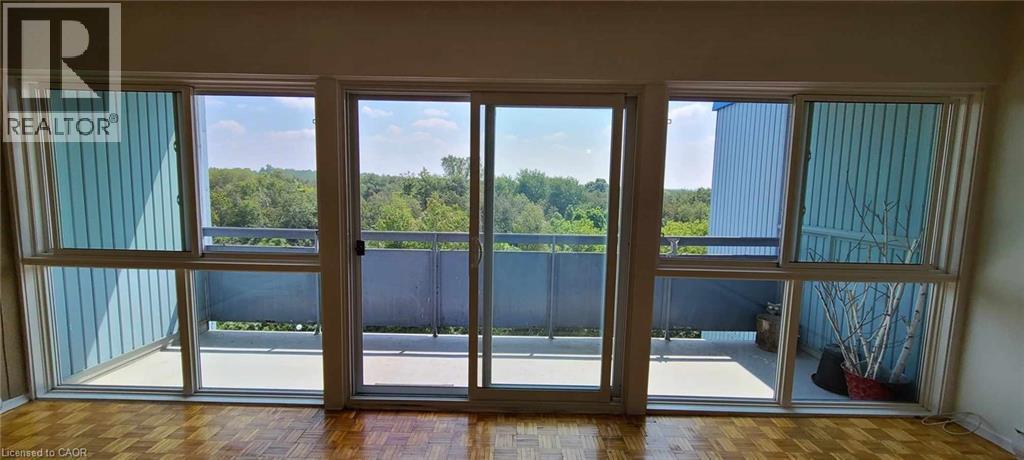 Expansive wall of windows with sliding glass doors opening to a private balcony - 105 Conroy Crescent Unit# 505, Guelph, ON