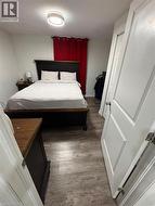 Neutral wall paint and wood-finish flooring with a modern flush-mount ceiling light -