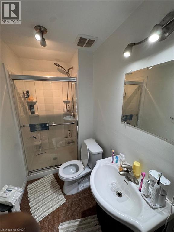Contemporary bathroom featuring a shower with a sliding glass door, a wall-mounted sink, and track lighting - 1377 Coronation Drive, London, ON - Indoor Photo Showing Bathroom