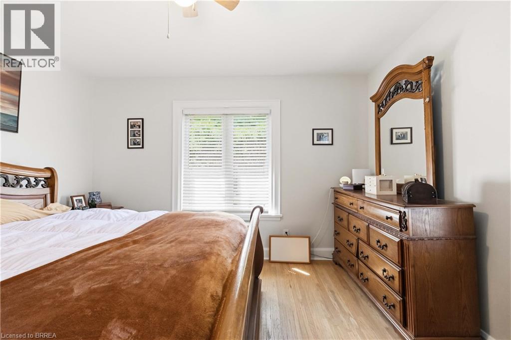 Hardwood flooring throughout featuring light-colored walls and a window with blinds - 134 Queensway Drive, Brantford, ON