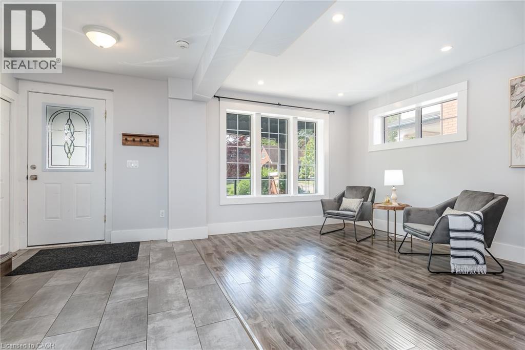 Entryway featuring a white door with decorative glass inlay, recessed lighting, wood-finish flooring, and a large window providing ample ambient light - 40 Woodland Avenue, Kitchener, ON