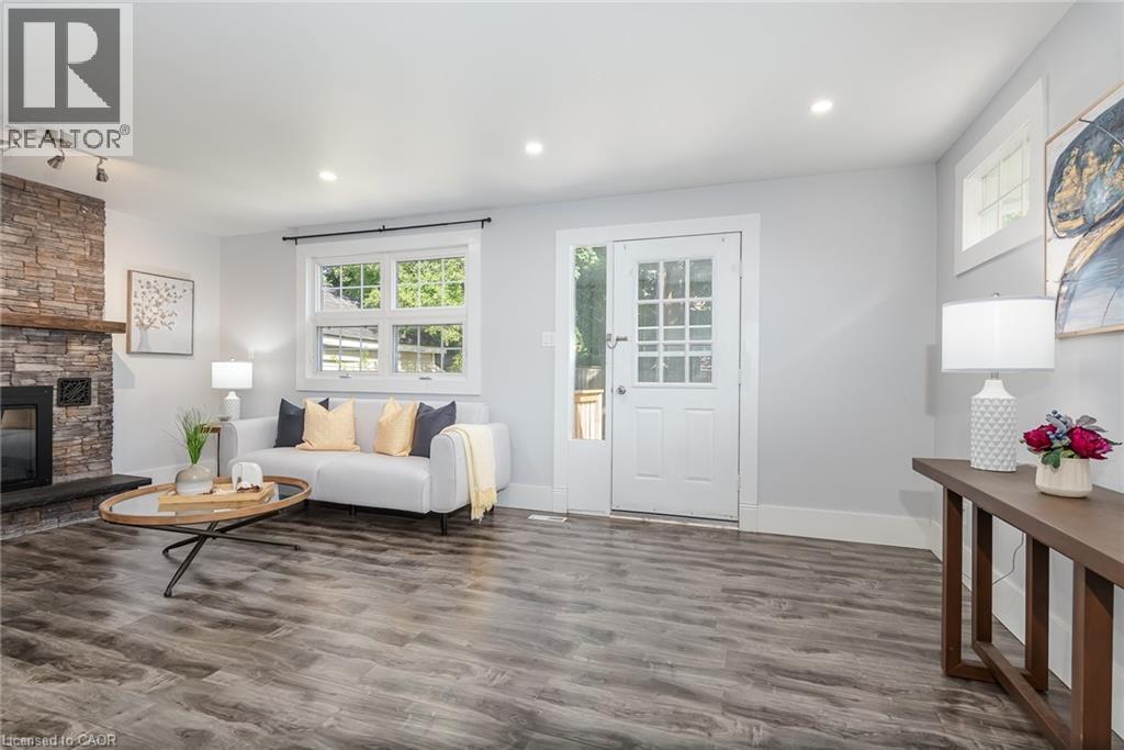 Expansive backyard featuring a wood deck, concrete pathway, and mature trees - 40 Woodland Avenue, Kitchener, ON