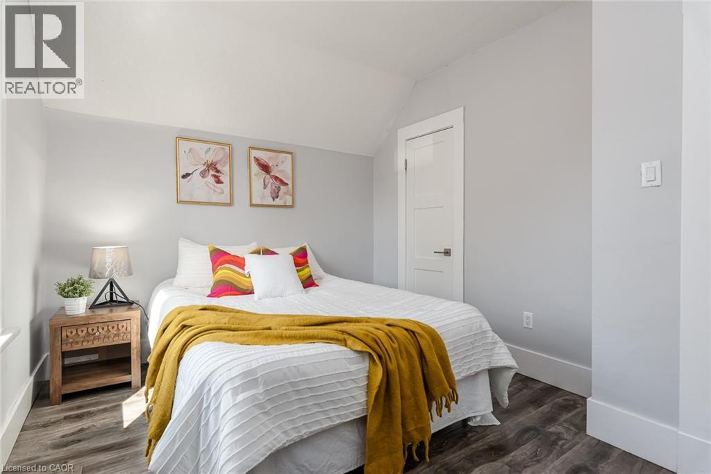 Light-filled interior featuring wood-finish flooring, white trim, and a contemporary door with dark hardware - 40 Woodland Avenue, Kitchener, ON