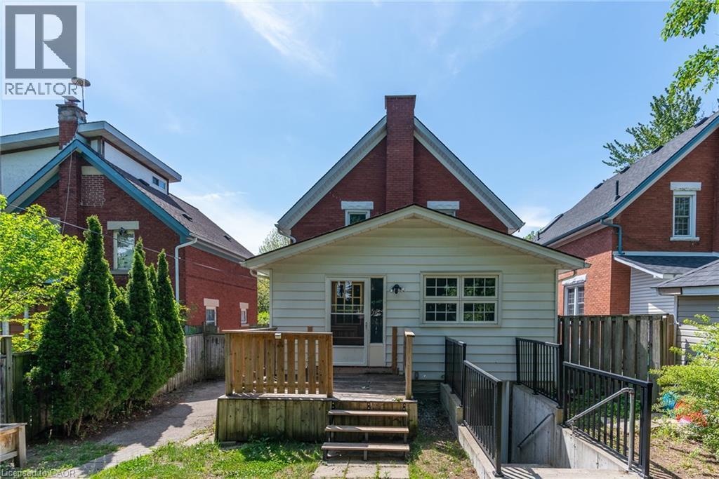 Rear exterior featuring a white siding extension with a wood deck and stairs - 40 Woodland Avenue, Kitchener, ON