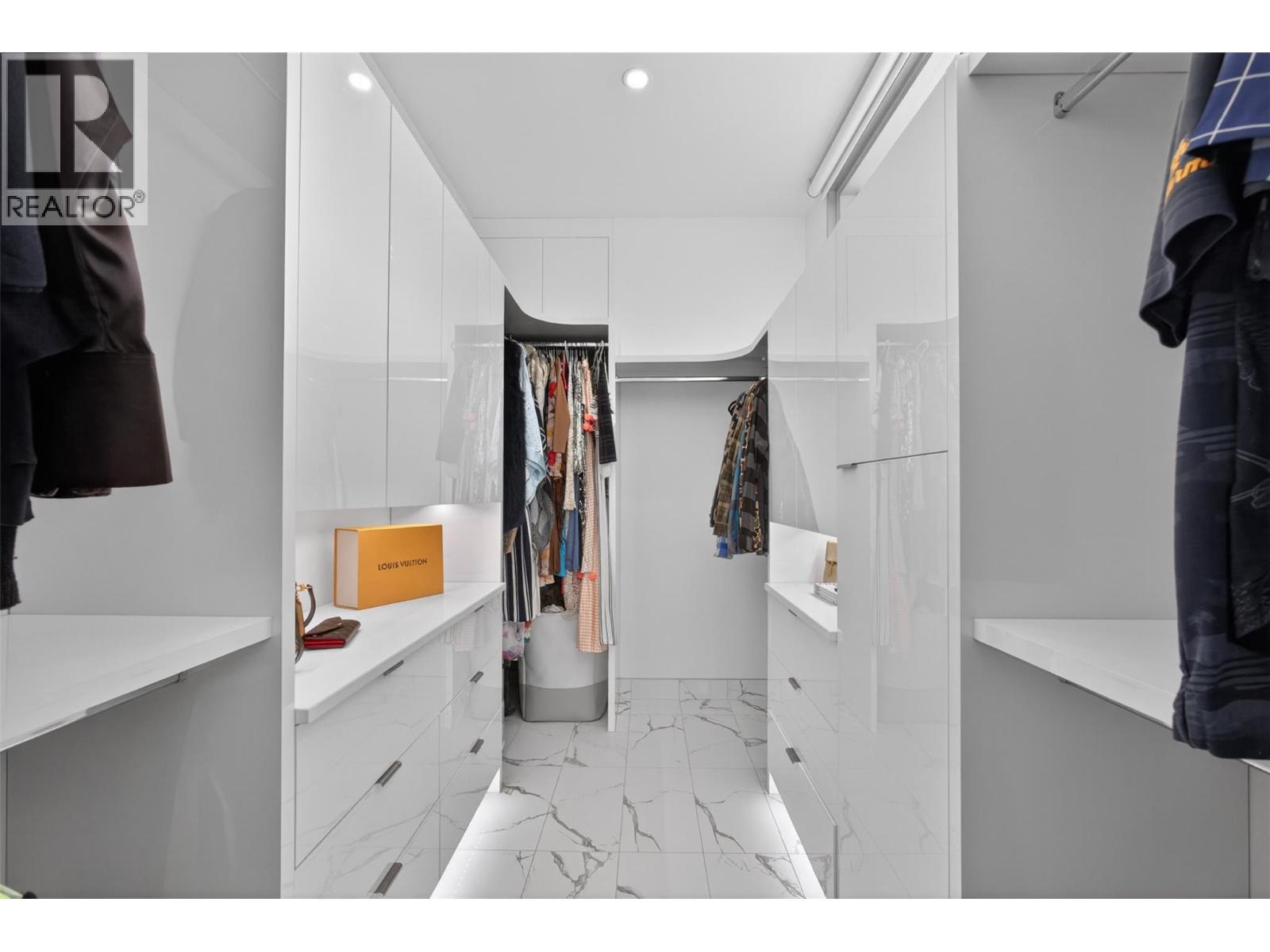 The oversized walk-in closet features custom cabinetry along with a custom soft-close glass barn door finished with a full-size mirror on the reverse side. - 5835 Vicary Road, Peachland, BC