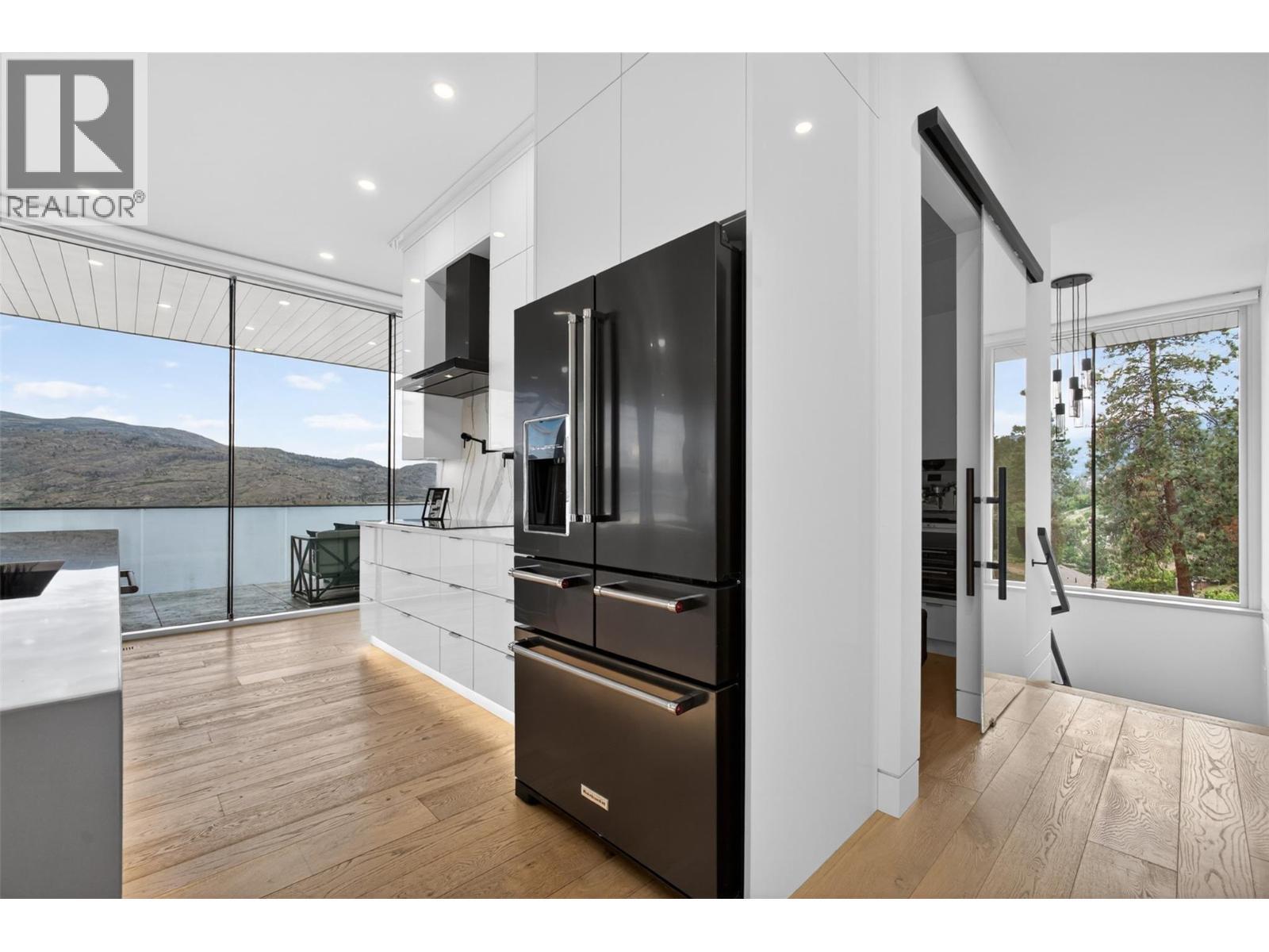The home also includes an oversized butler’s kitchen designed to conceal day-to-day preparation and appliances behind a custom soft-close glass barn door. - 5835 Vicary Road, Peachland, BC