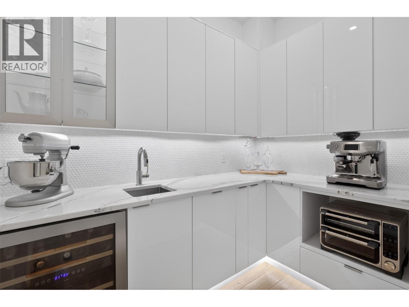 Butlers pantry with sink and beverage fridge. Under cabinet lighting - 5835 Vicary Road, Peachland, BC
