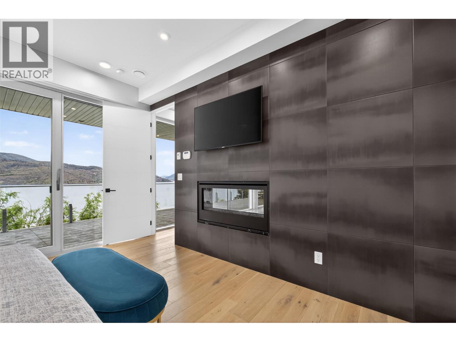 Large bedroom in legal suite with large windows open directly onto a private deck measuring approximately 10.5 ft. x 70 ft. (roughly 735 sq. ft.), complete with its own natural gas BBQ hookup. - 5835 Vicary Road, Peachland, BC
