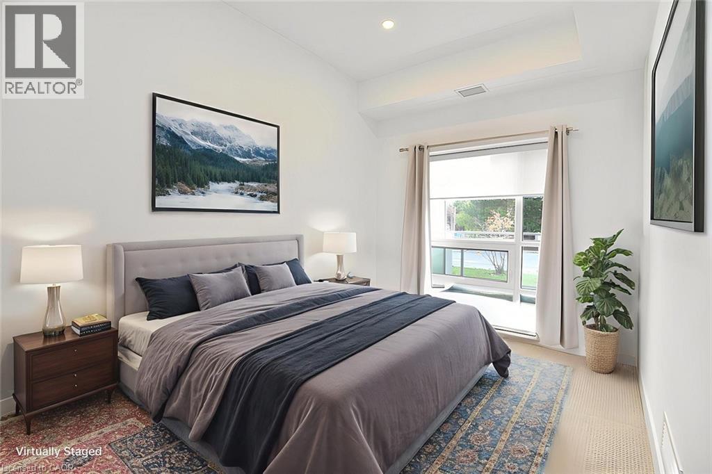 Spacious room featuring a vaulted ceiling, recessed lighting, and a large window with direct exterior access - 4040 Upper Middle Road Unit# 105, Burlington, ON