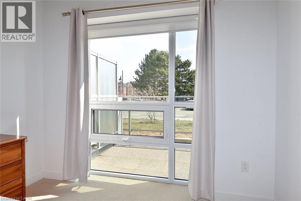 Floor-to-ceiling window offering natural light, featuring white frames and a operable lower section - 4040 Upper Middle Road Unit# 105, Burlington, ON