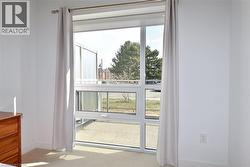 Floor-to-ceiling window offering natural light, featuring white frames and a operable lower section -