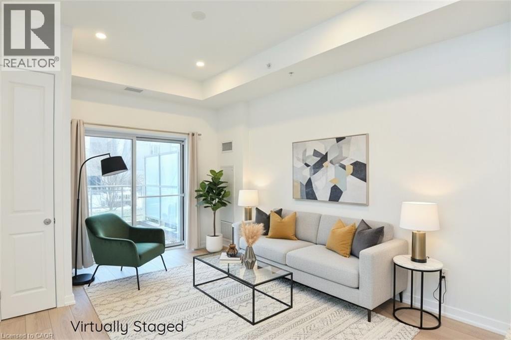 Living area featuring light wood-finish flooring, white walls, and recessed lighting - 4040 Upper Middle Road Unit# 105, Burlington, ON