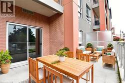 Private patio featuring brick cladding, sliding glass doors, concrete flooring, and a frosted glass privacy screen -