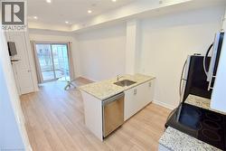 Kitchen with granite countertops, stainless steel sink, and integrated dishwasher -