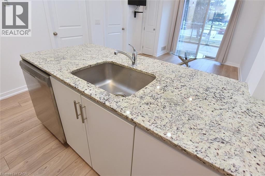 Kitchen island featuring a stainless steel undermount sink, a chrome faucet, and integrated stainless steel dishwasher - 4040 Upper Middle Road Unit# 105, Burlington, ON