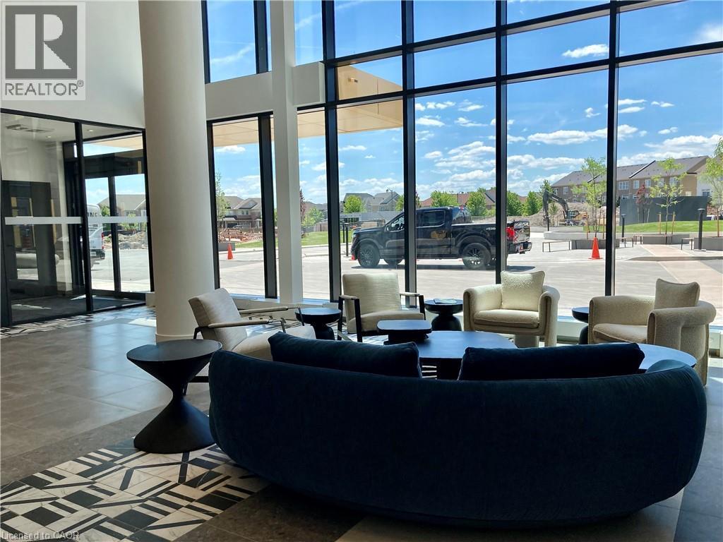Spacious lobby featuring floor-to-ceiling windows, high ceilings, a decorative tile inlay, and a modern entryway with glass doors - 4878 Powers Common Unit# C-1105, Burlington, ON