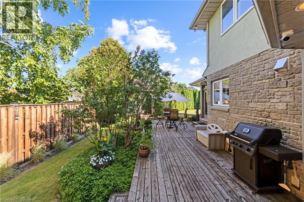 Expansive wood deck with direct access to the home's exterior, featuring a stone facade and stucco finish - 7775 St. Augustine Crescent, Niagara Falls, ON