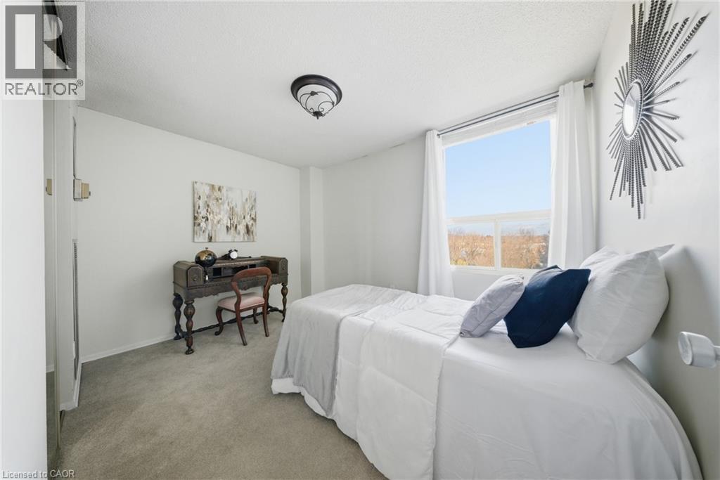 Room featuring light gray carpet flooring, white walls, and a prominent window - 2055 Upper Middle Road Unit# 602, Burlington, ON