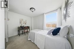 Room featuring light gray carpet flooring, white walls, and a prominent window -