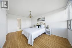 Bright room featuring wood-finish flooring, a contemporary ceiling light fixture, and a large window -
