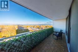 Balcony with wood-finish tile flooring and a privacy screen -