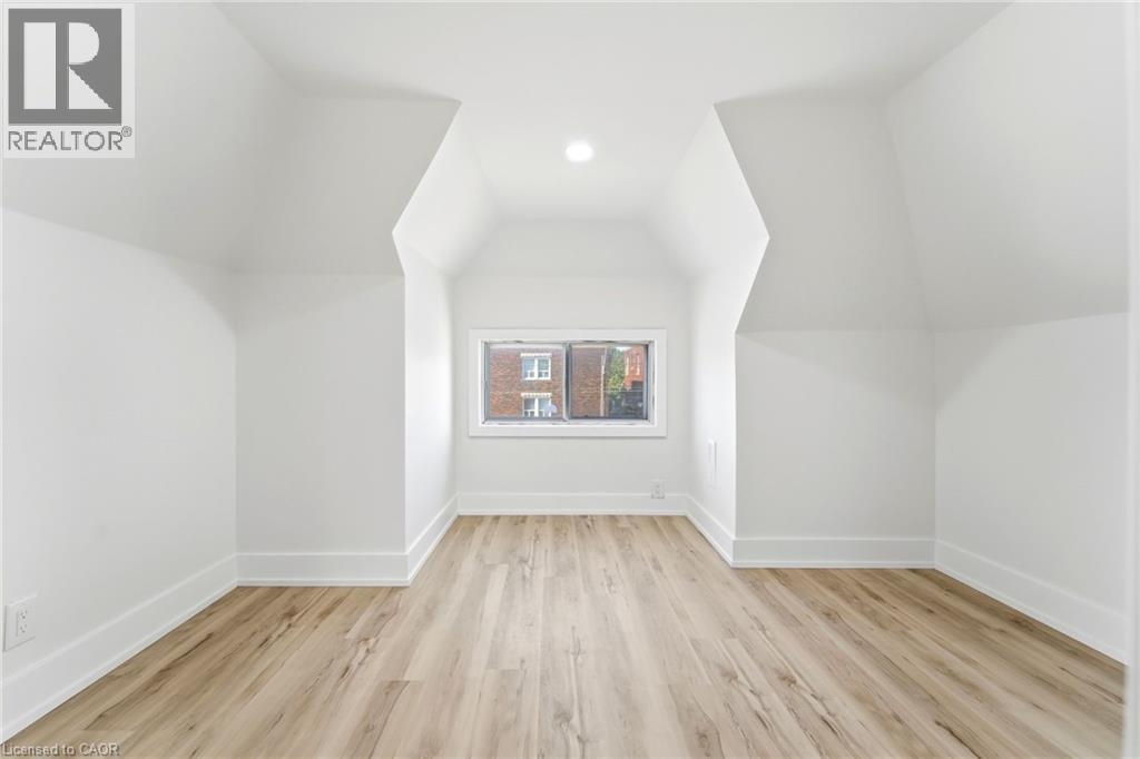 Attic space with sloped ceilings and light wood-finish flooring - 968 Main Street E, Hamilton, ON