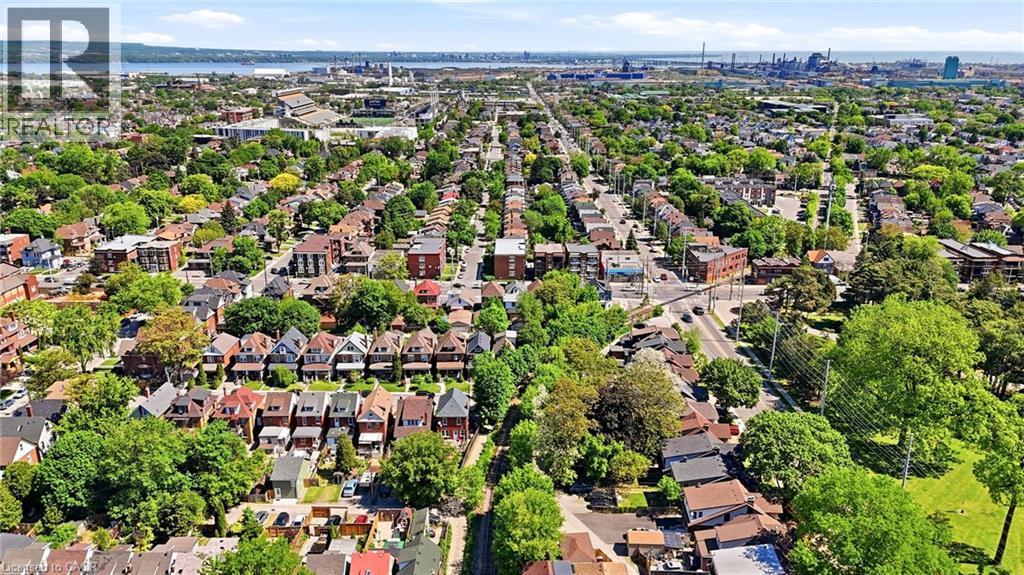 Expansive aerial perspective showcasing a residential area with a mix of architectural styles, tree-lined streets, and open green spaces - 968 Main Street E, Hamilton, ON - Outdoor With View